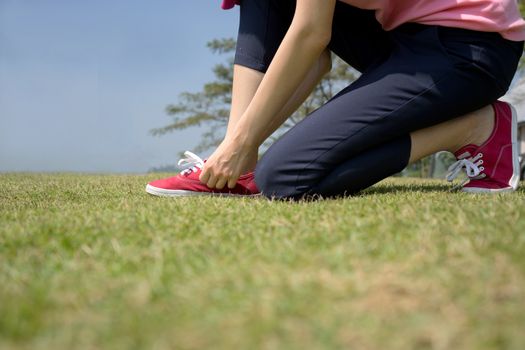 young asian woman tying shoelace