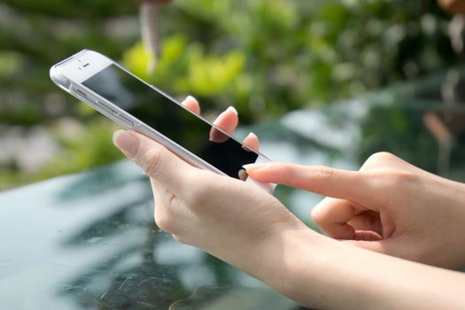 Closeup image of a female hands using smartphone