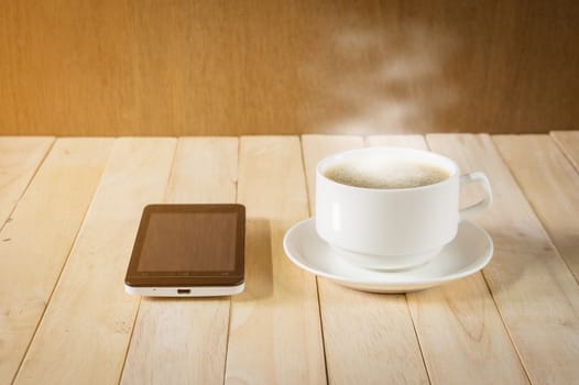 warm cup of coffee on wood background.
