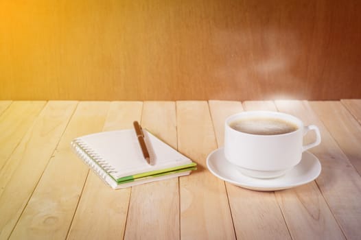 warm cup of coffee on wood background.