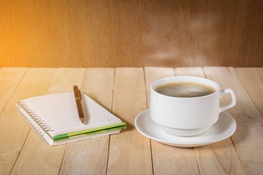 warm cup of coffee on wood background.