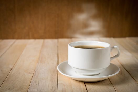 warm cup of coffee on wood background.