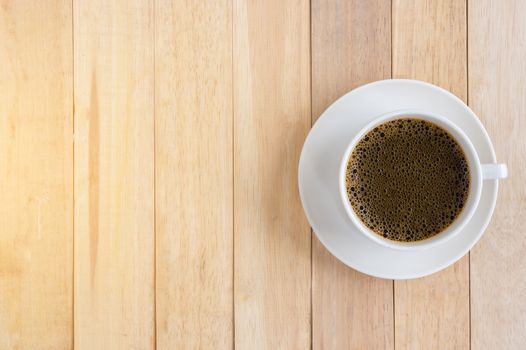 Cup of coffee on wood background.