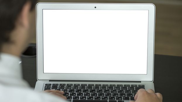 Closeup of businessman typing on laptop with blank screen. Mock up.