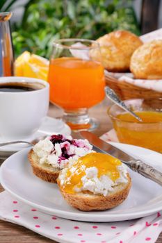 Breakfast of bun with ricotta orange and cherry jam