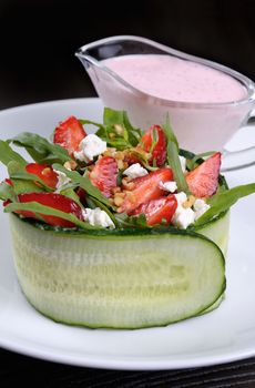 portion of strawberry salad with arugula and ricotta in cucumber
