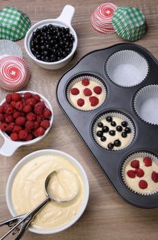 Preparation for baking muffins stuffed with raspberries and black currants