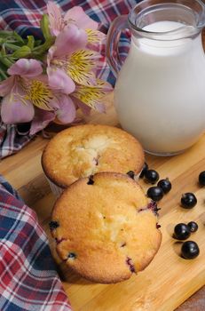 Muffins with filling  the table with carafe of milk and berries