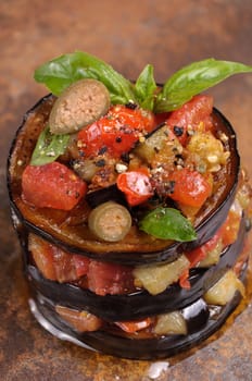 Appetizer of fried eggplant with diced tomatoes, capers, flavoured spices
