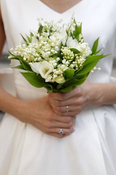 The bride holds a wedding bouquet