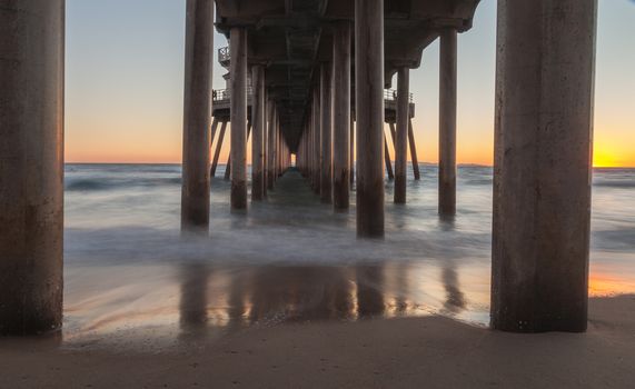 Under the Huntington Beach Pier in Huntington Beach, California, United States at sunset in the fall