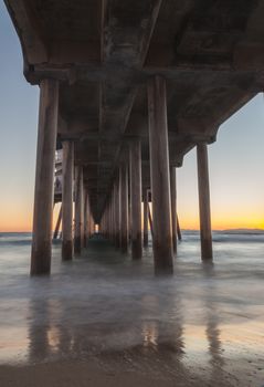 Under the Huntington Beach Pier in Huntington Beach, California, United States at sunset in the fall