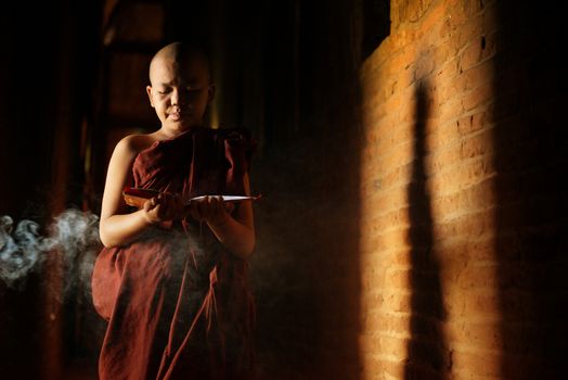 Young novice monk learning inside monastery.