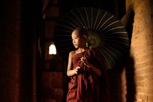 Young novice monks walking thru a Buddhist temple, Bagan, Myanmar.