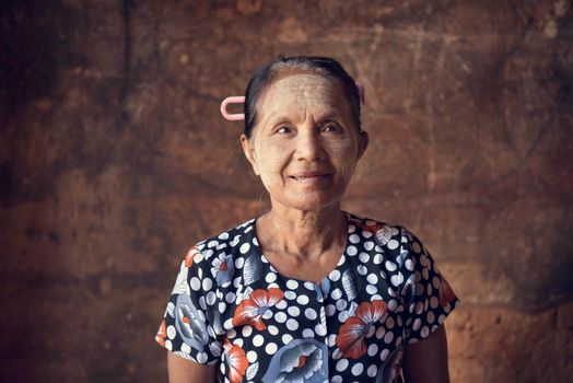 Portrait of traditional Asian Burmese woman standing inside a temple, low light, Bagan, Myanmar