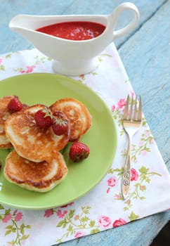 Breakfast serving of pancakes with strawberries and strawberry sauce in a pot in the style of a romantic