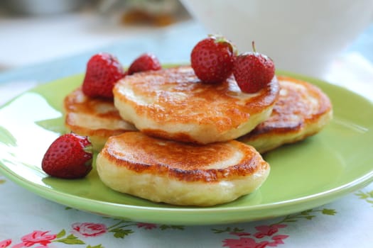 Breakfast serving of pancakes with strawberries and strawberry sauce in a pot in the style of a romantic