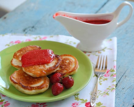 Breakfast serving of pancakes with strawberries and strawberry sauce in a pot in the style of a romantic