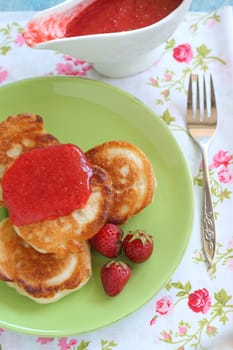 Breakfast serving of pancakes with strawberries and strawberry sauce in a pot in the style of a romantic