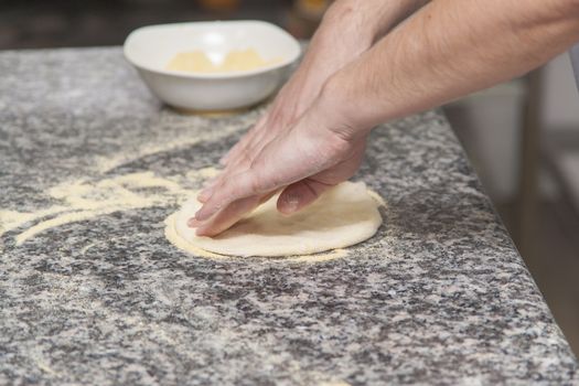 Woman chef with raw dough. Young female in uniform preparing bread dough on table.