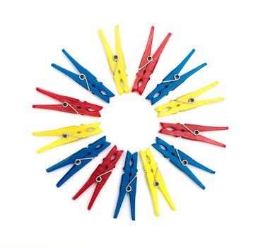 Multicoloured plastic clothes pegs on a white background