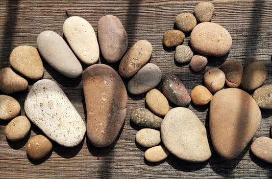 Abstract cute concept on wood background from pebbles, amazing arranged boulder to family of footprint, awesome shape from pebblestone