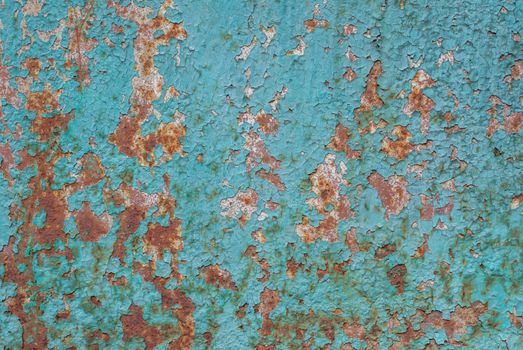 rusty iron surface covered with old chipped turquoise color paint, which has long been influenced by different climatic conditions