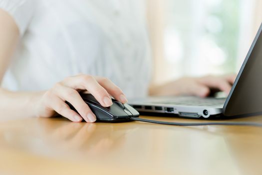 Image of female hands clicking computer mouse