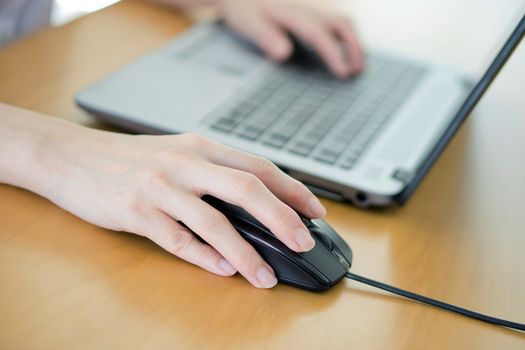 Female hand with computer mouse on table, closeup