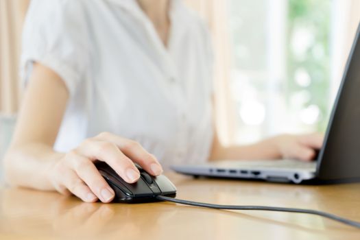 Image of female hands clicking computer mouse