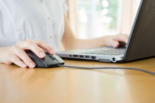 Image of female hands clicking computer mouse