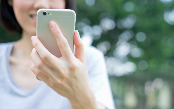 woman using mobile smart phone in the park