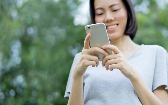 woman using mobile smart phone in the park