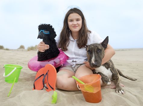 young girl and her two dogs on the beach