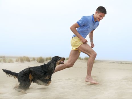 man playing with his dog on the beach