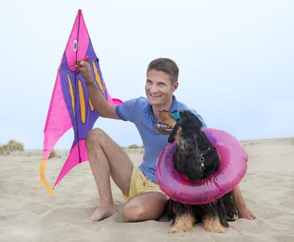 man, kite and dog on the beach