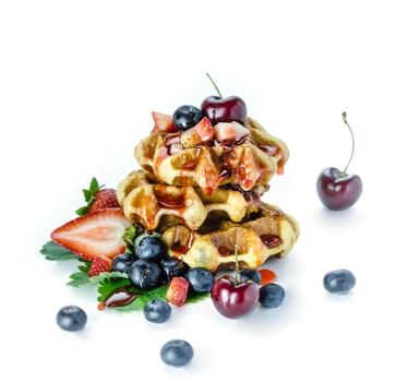 Homemade waffles with strawberry sauce and fresh berries on white background