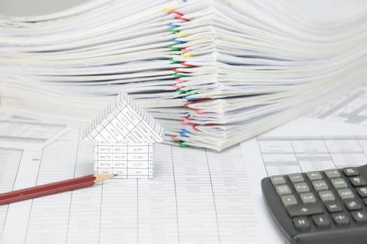 Close up house and pencil on finance account have blur pile overload paperwork of report and receipt with colorful paperclip and calculator place on white background.