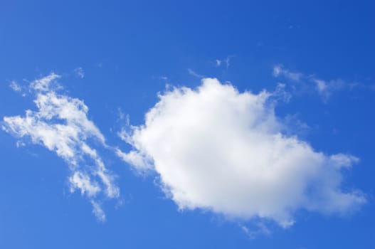 Big white puffy cumulus cloud on the blue sky as background.