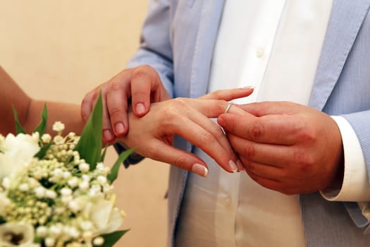 Groom wears a wedding ring to the bride