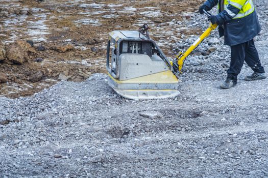 Vibration plate, plate compactor on a construction site in use