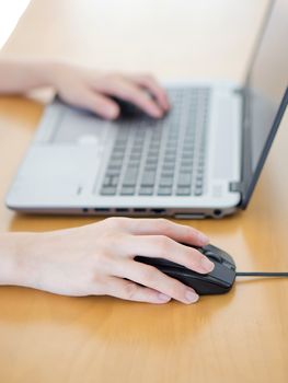 Female hand with computer mouse on table, closeup