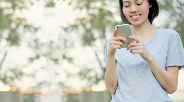 woman using mobile smart phone in the park