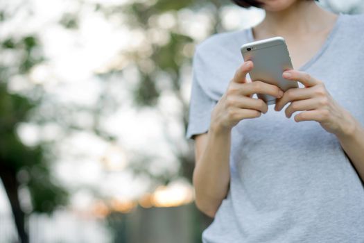 woman using mobile smart phone in the park