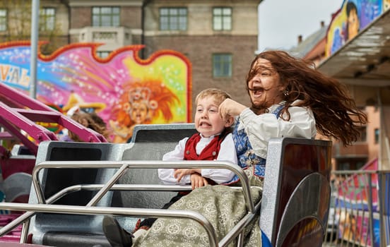 Mother and Son laughing in a carousel in an amusement park.