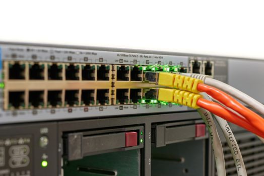 Network switch with ethernet cables on top of a server.