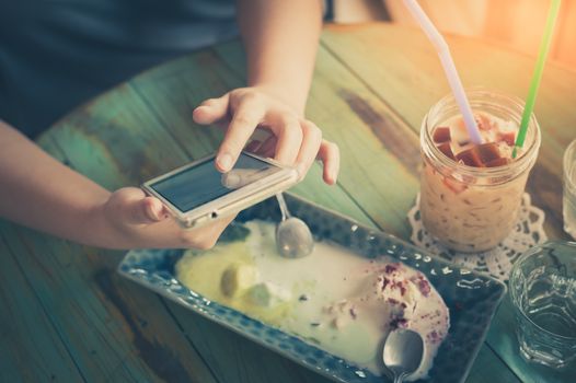 Afternoon scene of young woman using smartphone for social networking in cafe on weekend. Trendy lifestyle concept with technology. processed with vintage filter effect