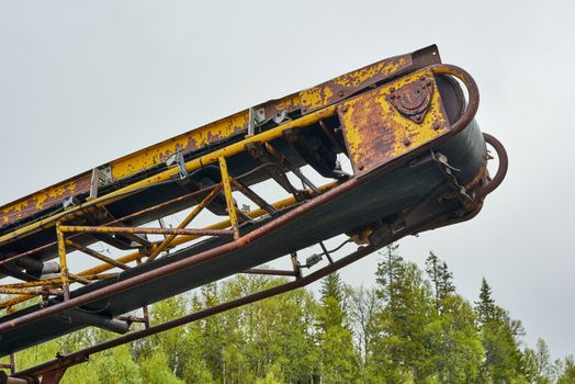 Rusty old conveyor belt found in a forest.