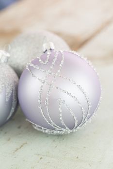 Decorated silver Christmas baubles with focus to a single bauble in the foreground to celebrate Xmas and the festive holiday season