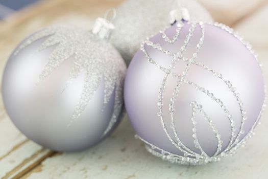 Decorated silver Christmas baubles with focus to a single bauble in the foreground to celebrate Xmas and the festive holiday season